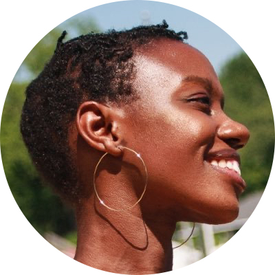 Side profile of Rachel Nyakaana Blair smiling, wearing hoop earring